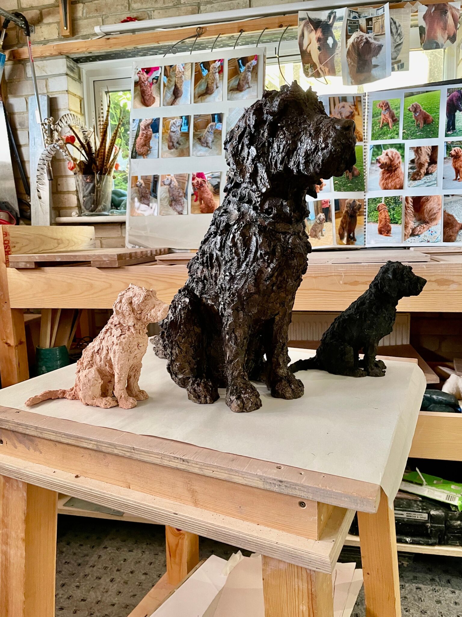 This sculpture is a life sized dog which was commissioned by a client. The dog is called Jess. This is a sculpture of interior display. Shown either side of the life sized model are two miniature studies of Jess. The miniature study on the right is in a biscuit colour and the miniature study on the left is in black.